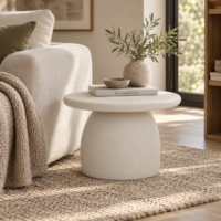 Mesa de centro de cemento redonda de 60 cm con base central curva y diseño escultórico en salón moderno de tonos neutros