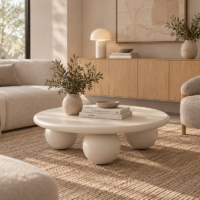 Mesa de centro redonda color cemento de 90 cm con apoyos esféricos y diseño escultórico para salón moderno